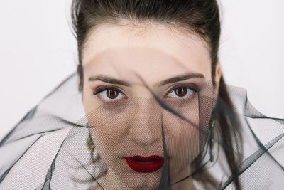 Close-up portrait of woman against white background