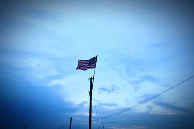 Low angle view of flag against blue sky