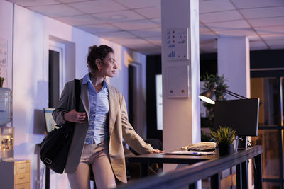 Portrait of young woman standing in office