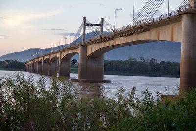 Arch bridge over river against sky