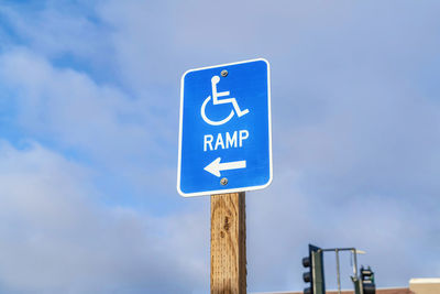 Low angle view of information sign against blue sky