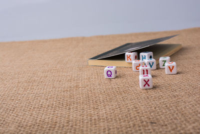 Close-up of colorful alphabets on dices with book at table