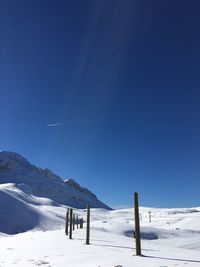 Scenic view of snowcapped mountains against clear blue sky