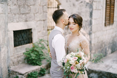 Side view of bride holding bouquet