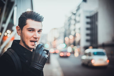 Close-up portrait of man with buildings in background