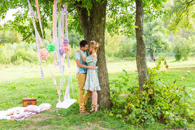 Couple standing by tree in park