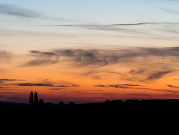 Scenic view of silhouette landscape against orange sky