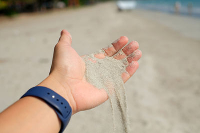 Close-up of person hand on sand