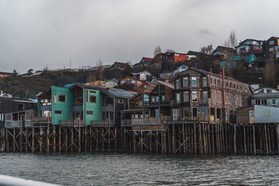 Buildings by sea against sky