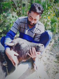 Full length of man holding buffalo