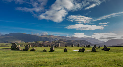 Scenic view of field against sky with a stone circle prominent in the foreground 