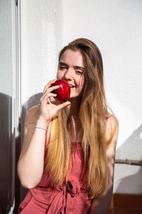 Portrait of young woman eating apple