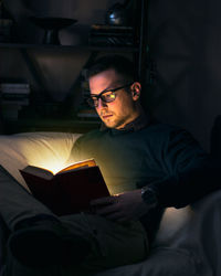 Young man sitting on book