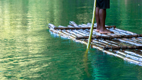 Low section of man standing in lake