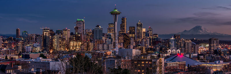 Illuminated cityscape against sky at night