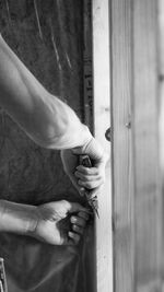 Cropped hands of man using tool on wood