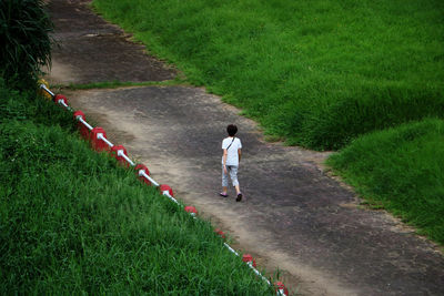 Rear view of man walking on footpath