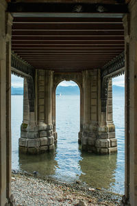 Arch bridge over sea against sky