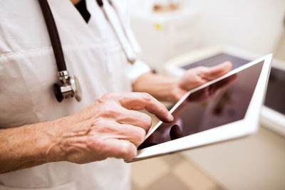 Close-up of vet using tablet in clinic