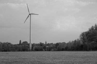 Windmills on field against clear sky