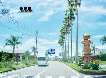 Statue by road against sky