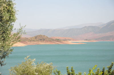 Scenic view of sea and mountains against sky