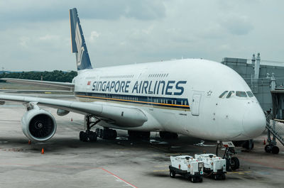 Airplane on airport runway against sky