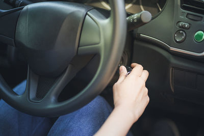 Midsection of person using smart phone in car