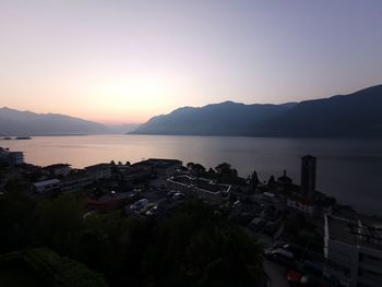 High angle view of buildings by sea against sky during sunset