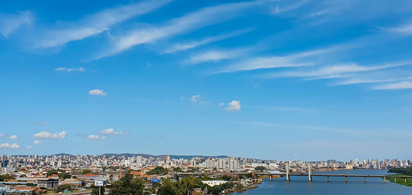 Aerial view of buildings in city against cloudy sky