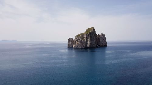 Scenic view of rock formation in sea against sky