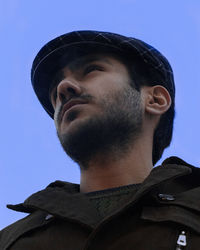 Side view of man against blue sky