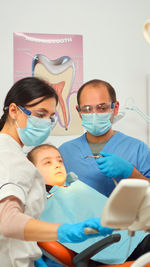 High angle view of female doctor examining patient at clinic