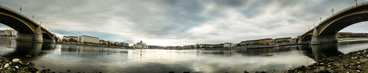 Bridge over river against cloudy sky