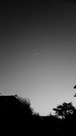 Low angle view of silhouette trees against clear sky