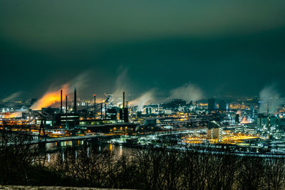 Illuminated cityscape against sky at night