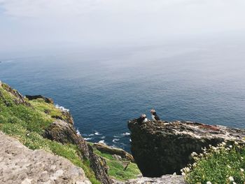 High angle view of rocks by sea against sky