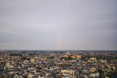 High angle view of townscape against rainbow in sky