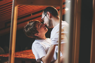 Side view of couple kissing at night