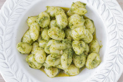 Close up of a plate of green gnocchi.