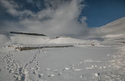 Scenic view of snow covered land against sky