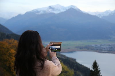 Woman photographing against mountain