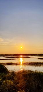 Scenic view of lake against sky during sunset