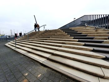 Man on staircase against sky