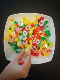 High angle view of woman holding multi colored candies