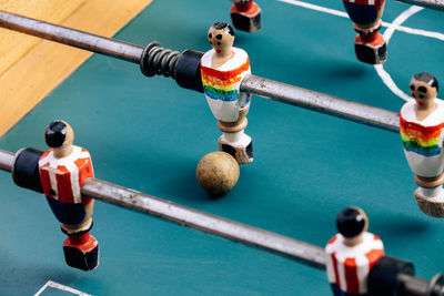 High angle of detail of retro table soccer with wooden miniature figurines of players on metal bars