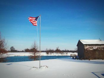 Flag on pole against clear blue sky