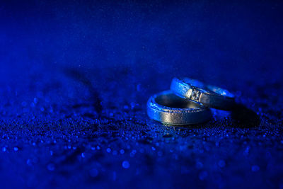Close-up of wedding rings on blue metal