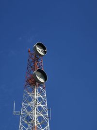 Low angle view of electricity pylon against clear blue sky