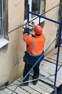 Rear view of man standing on railing